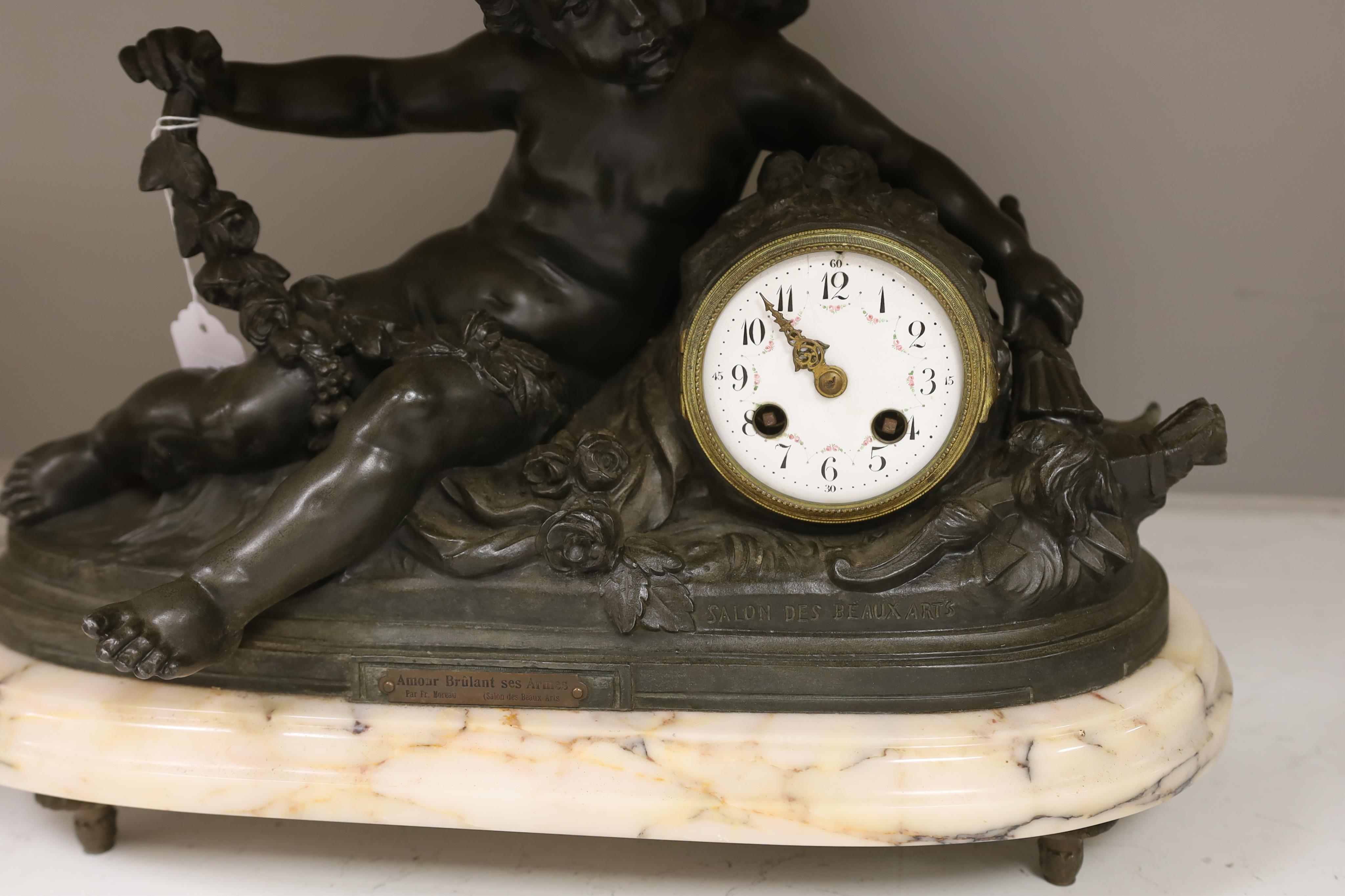 After Francois Hippolyte Moreau (French, 1832-1926), a late 19th century bronze cherubic mantel clock on marble base, ‘Amour Brûlant Ses Armes’, no key or pendulum, 34cm high. Condition - clock glass missing, not known i